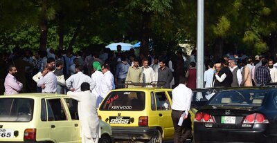 Pakistani federal employees gather outside their offices after a 7.5-magnitude earthquake in Islamabad on Monday. (Farooq Naeem/AFP/Getty Images)