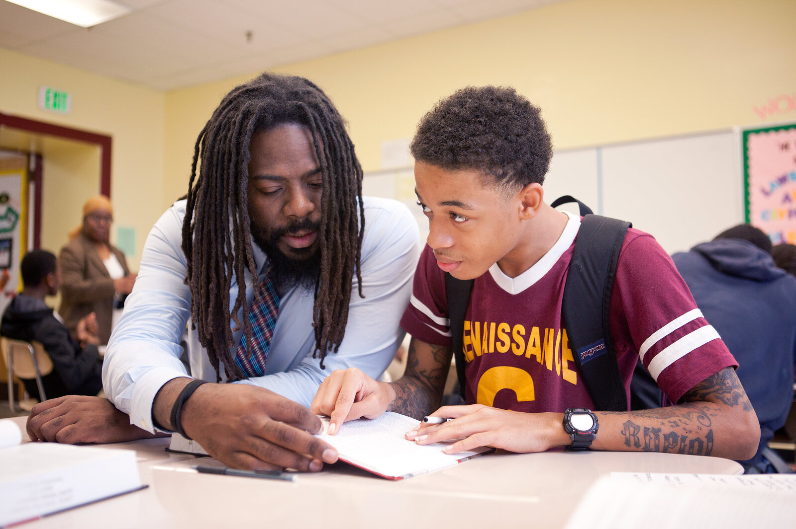 Mentor Antwon Cooper (left) helps student Julius Barne, 15, during a group activity in a history class. Mentor Antwon Cooper (left) helps student Julius Barne, 15, during a group activity in a history class.