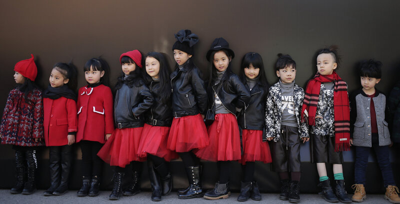 Models for children's wear wait for a show during China Fashion Week in Beijing on Thursday. China announced an end to the one-child policy for urban couples that had been place for more than three decades.