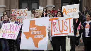 Abortion rights activists hold signs during a rally on the steps of the Texas Capitol in June.