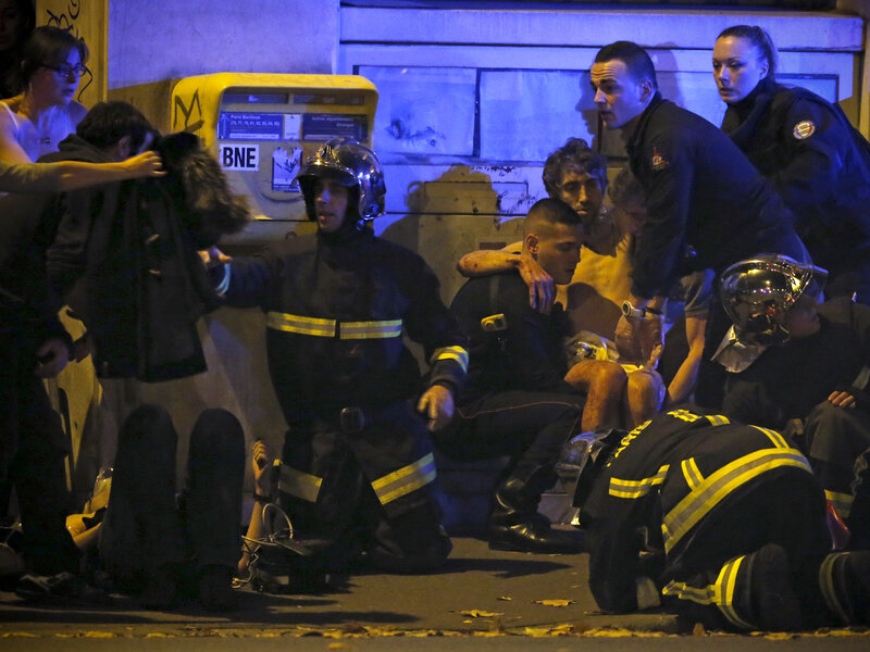 Membres de la brigade d'incendie de l'aide française un individu blessé près de la salle de concert Bataclan suivante tirs mortels à Paris, France. Membres de la brigade d'incendie de l'aide française un individu blessé près de la salle de concert Bataclan suivante tirs mortels à Paris, France.