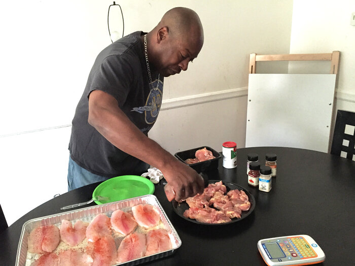 Felipa prepares dinner for his family at their home in West Baltimore, Md. (Jennifer Ludden/NPR)