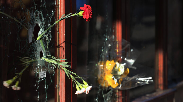 A flower is placed inside a bullet hole in the window of Le Carillon restaurant in tribute to the victims of the terror attacks on November 15 in Paris, France. (Christopher Furlong/Getty Images)