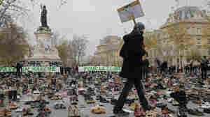 A man walks through hundreds of pairs of shoes displayed in Paris as part of a rally called "Paris sets off for climate" on Sunday, Nov. 29. More than 140 world leaders are gathering around Paris for high-stakes climate talks this week.