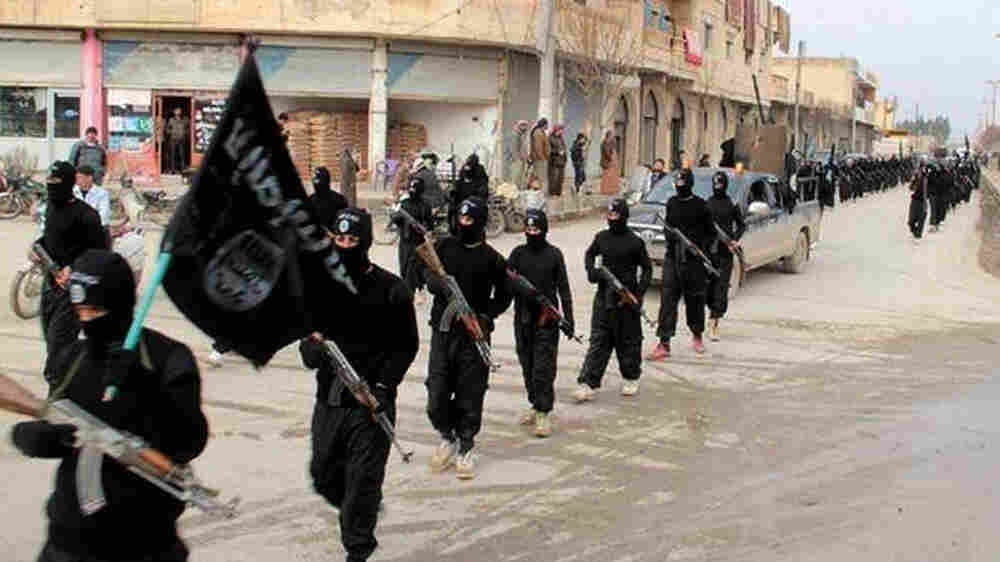 FILE - This undated file image posted on a militant website on Jan. 14, 2014, shows fighters from the Islamic State group marching in Raqqa, Syria. T (AP Photo/Militant Website, File)