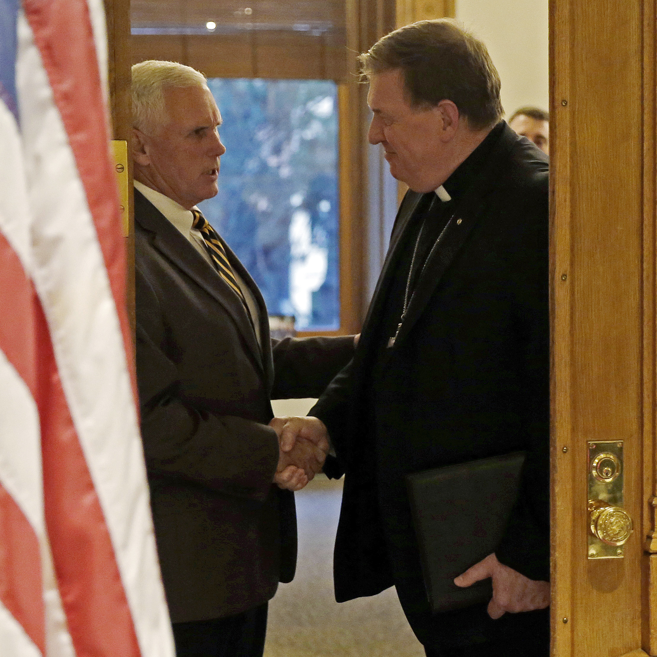 Indianapolis Archbishop Joseph Tobin (right) shakes hands with Indiana Gov. Mike Pence following a meeting at the Statehouse on Wednesday in Indianapolis.