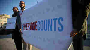 Activists hold signs during a news conference in front of the Supreme Court Tuesday.
