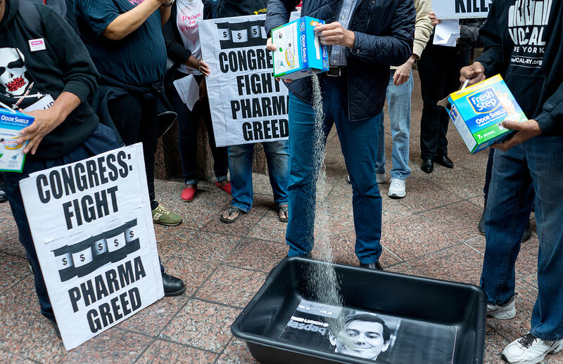 AIDS activists poured cat litter on an image of Turing Pharmaceuticals CEO Martin Shkreli during an October protest in New York. (Craig Ruttle/AP)