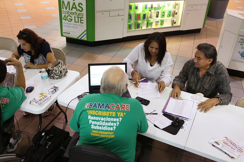 From left: Martha Lucia Bienvendida Barreno and Jorge Baquero discuss health insurance options with agents from Sunshine Life and Health Advisors at a Miami mall last month. (Joe Raedle/Getty Images)