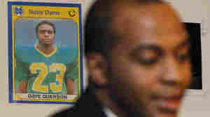 A photo of former Chicago Bears Dave Duerson, while he was playing at Notre Dame, hangs behind his son Tregg as Tregg announces a wrongful death lawsuit against the NFL in 2012.