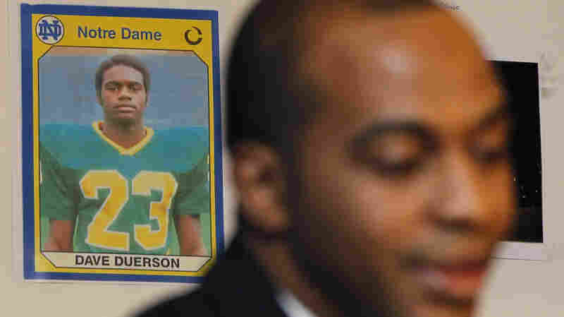 A photo of former Chicago Bears Dave Duerson, while he was playing at Notre Dame, hangs behind his son Tregg as Tregg announces a wrongful death lawsuit against the NFL in 2012.