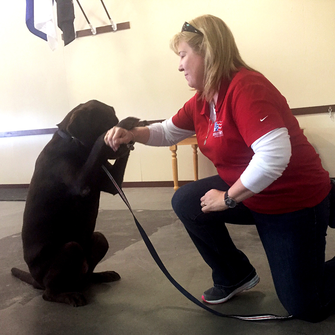 Cheryl Woolnough, director of training at Patriot PAWS in Rockwall, Texas, works with Papi, a Labrador retriever.