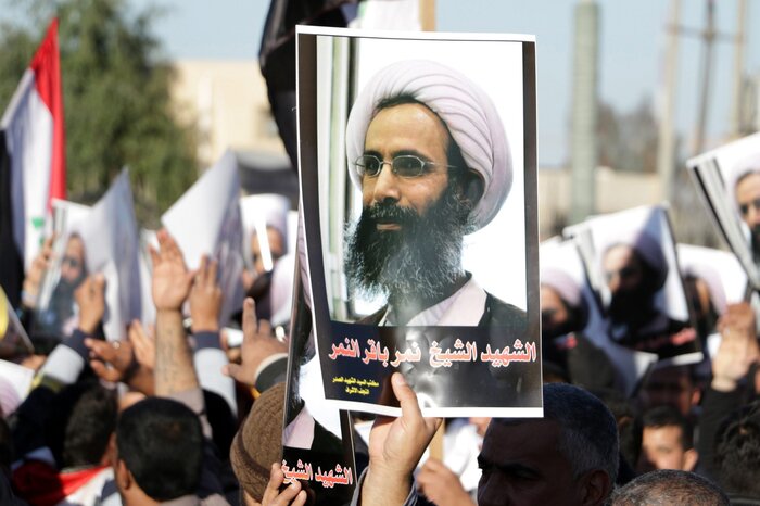 An Iraqi protester holds a poster of Shiite cleric Nimr al-Nimr, who was executed in Saudi Arabia, during a protest Monday in front of the gate of the Green Zone in Baghdad. (Ali Abbas/EPA /Landov)