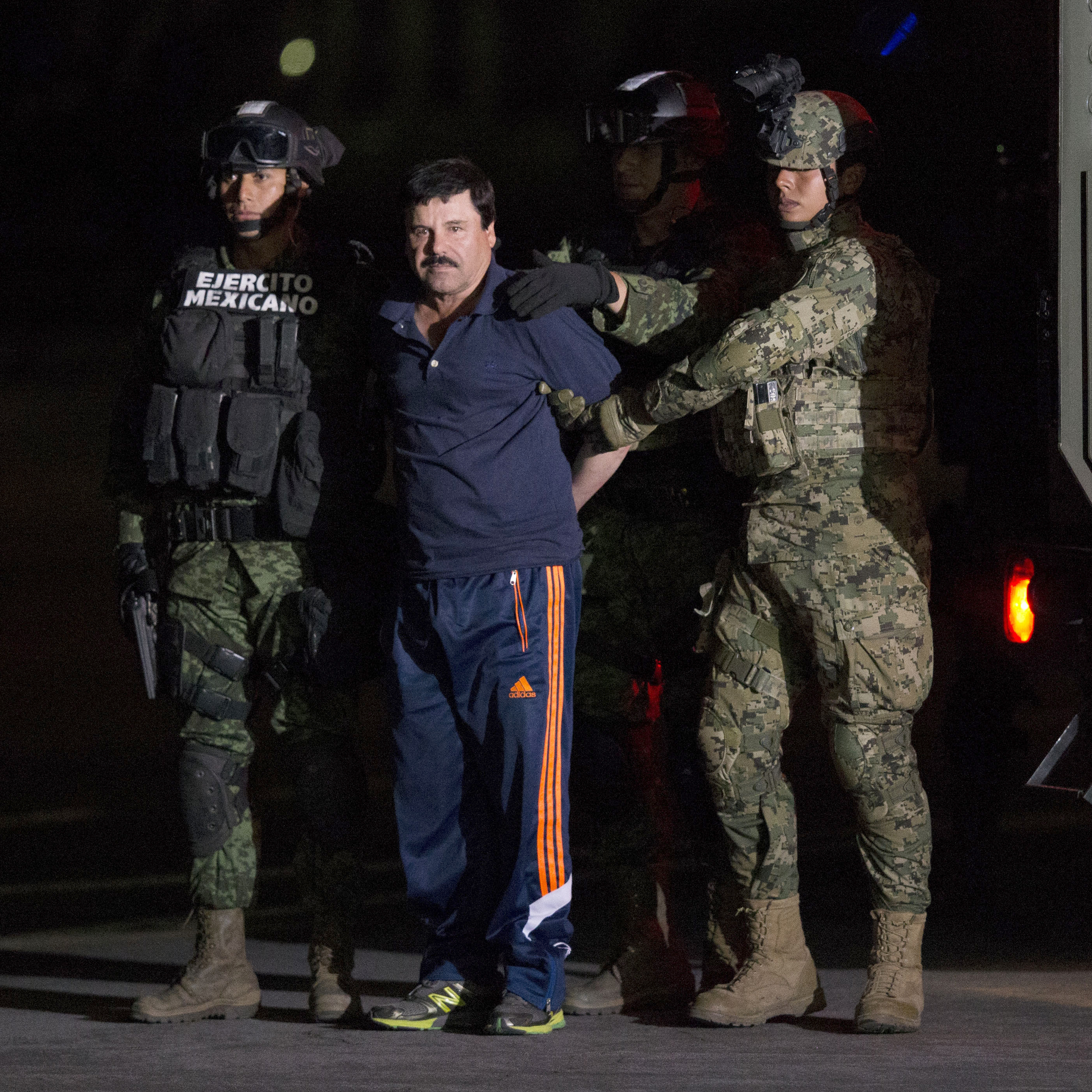 Mexican drug lord Joaquin "El Chapo" Guzman is escorted by army soldiers to a waiting helicopter, at a federal hangar in Mexico City Friday. The world's most wanted drug lord was recaptured six months after he fled through a tunnel from a maximum security prison in a made-for-Hollywood escape that deeply embarrassed the government and strained ties with the United States.
