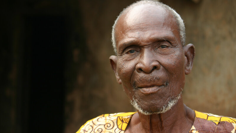 Bondi Sanbark, the chief in Beposo 2, says his village used to be full of blind men led around by boys — but that began to change when a new drug was distributed. (Jason Beaubien/NPR) Bondi Sanbark, the chief in Beposo 2, says his village used to be full of blind men led around by boys — but that began to change when a new drug was distributed. (Jason Beaubien/NPR)