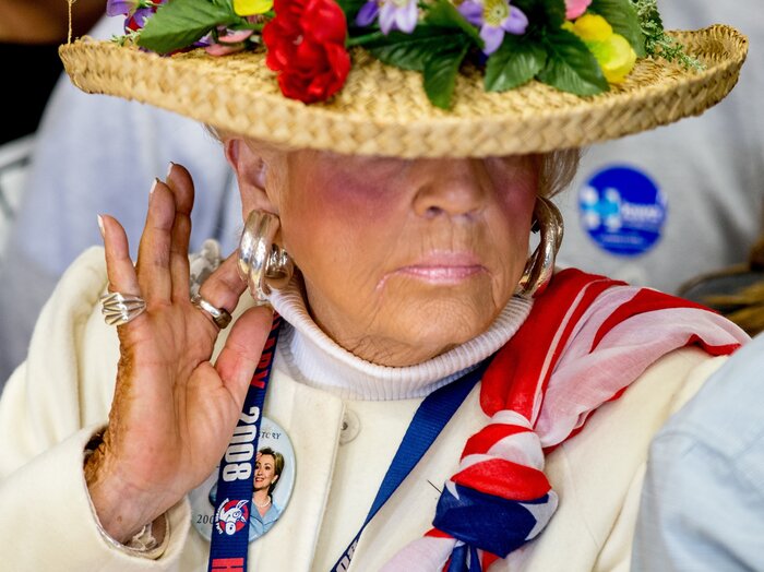 A woman at a Clinton event wears a campaign button as she stands in the audience during a rally for the candidate.
