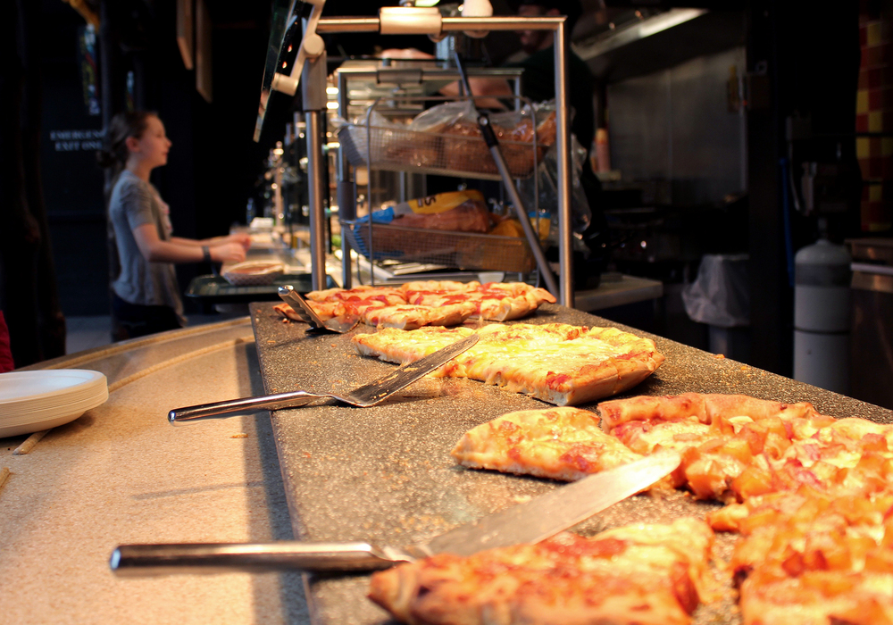 Heat lamps warm fresh pizza in the food line at the Cleveland Metroparks Zoo's Amazon Cafe in the Rainforest. The dining area has increased offerings of healthful foods such as salads, but pizza, fries and corn dogs remain popular choices among visitors.