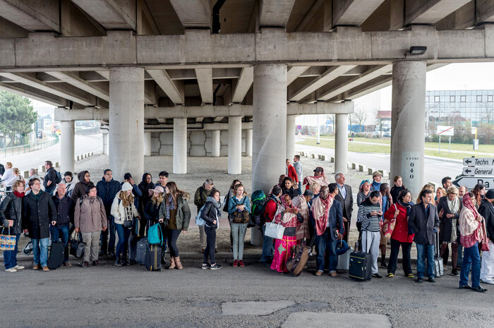 People stand near the airport after being evacuated following explosions that rocked the facility in Brussels. Belgium raised its terror alert to its highest level, diverting arriving planes and trains and ordering people to stay where they were.