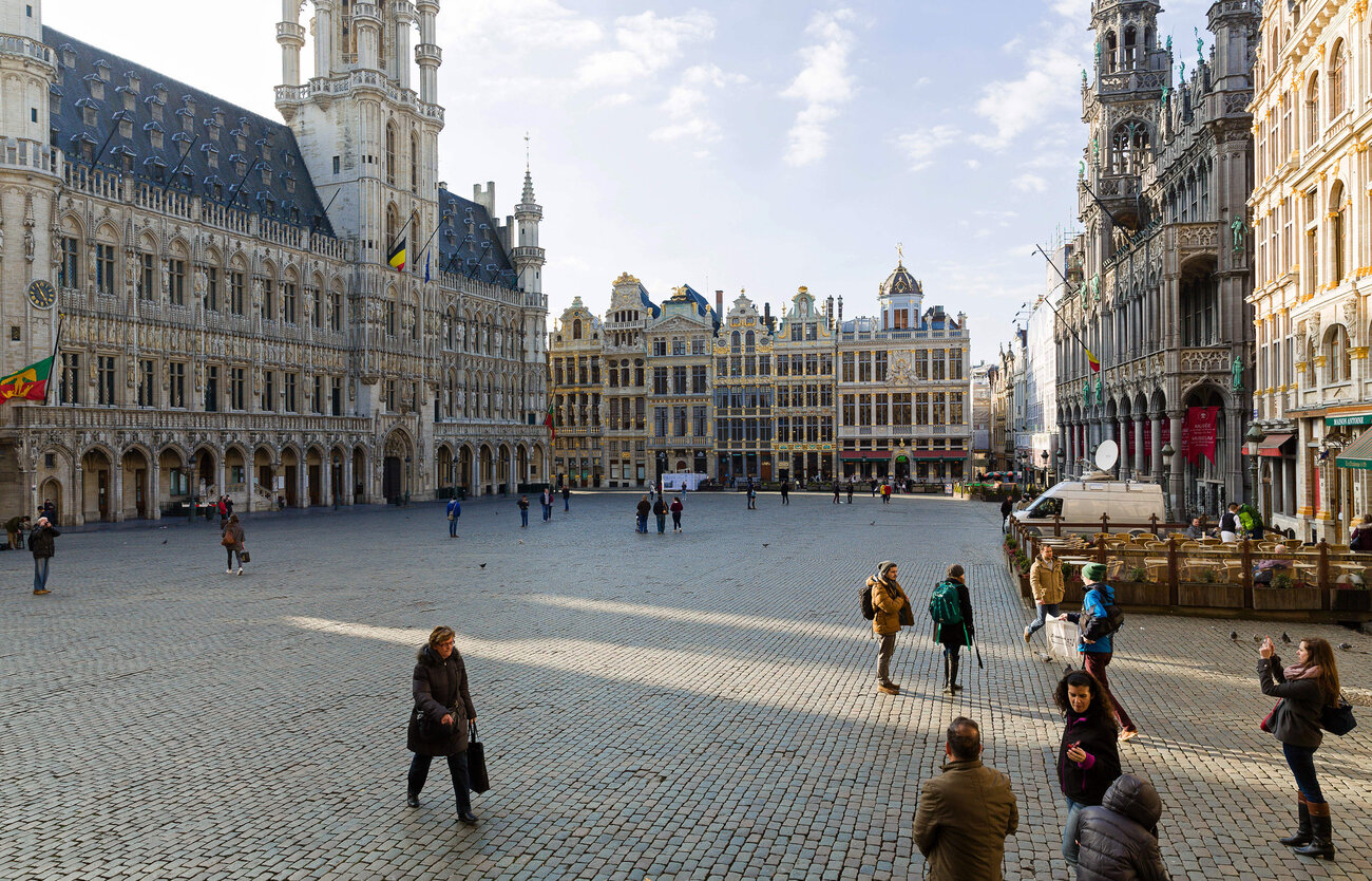 Tourists visit the nearly empty Grand Place in Brussels on Tuesday afternoon, after a string of explosions rocked Brussels airport and a city metro station.