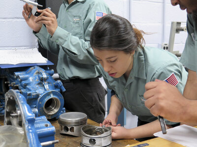 Joseline Lazo works on fixing a four-cylinder aircraft engine during class at JFK Airport. Joseline Lazo works on fixing a four-cylinder aircraft engine during class at JFK Airport.