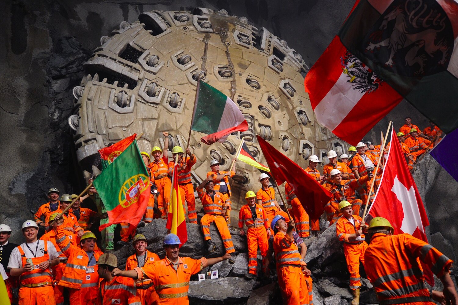 Miners celebrate beneath the Swiss Alps in 2010, after a giant drilling machine bored through to create the world's longest tunnel. After several more years of work, the train line through that tunnel is now open. Miners celebrate beneath the Swiss Alps in 2010, after a giant drilling machine bored through to create the world's longest tunnel. After several more years of work, the train line through that tunnel is now open.