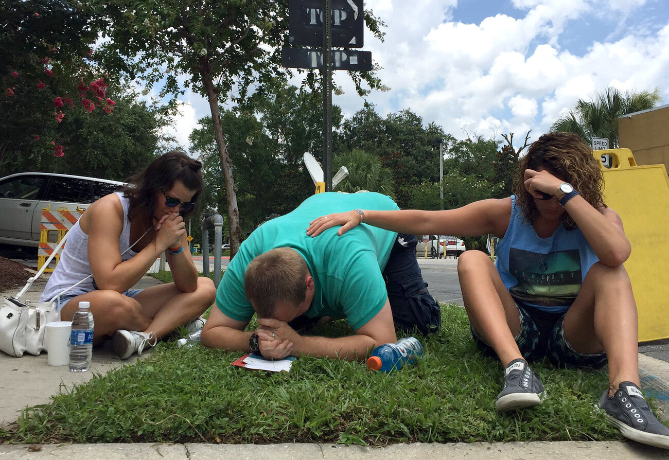 People pray on Orange Ave. in Orlando, near the Pulse night club. People pray on Orange Ave. in Orlando, near the Pulse night club.
