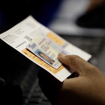 An election official checks a voter's photo identification at an early voting polling site in Austin, Texas.