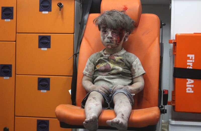 A 5-year-old boy, identified in news reports as Omran Daqneesh, sits in an ambulance Wednesday after reportedly being pulled out of a building hit by an airstrike in Aleppo, Syria.