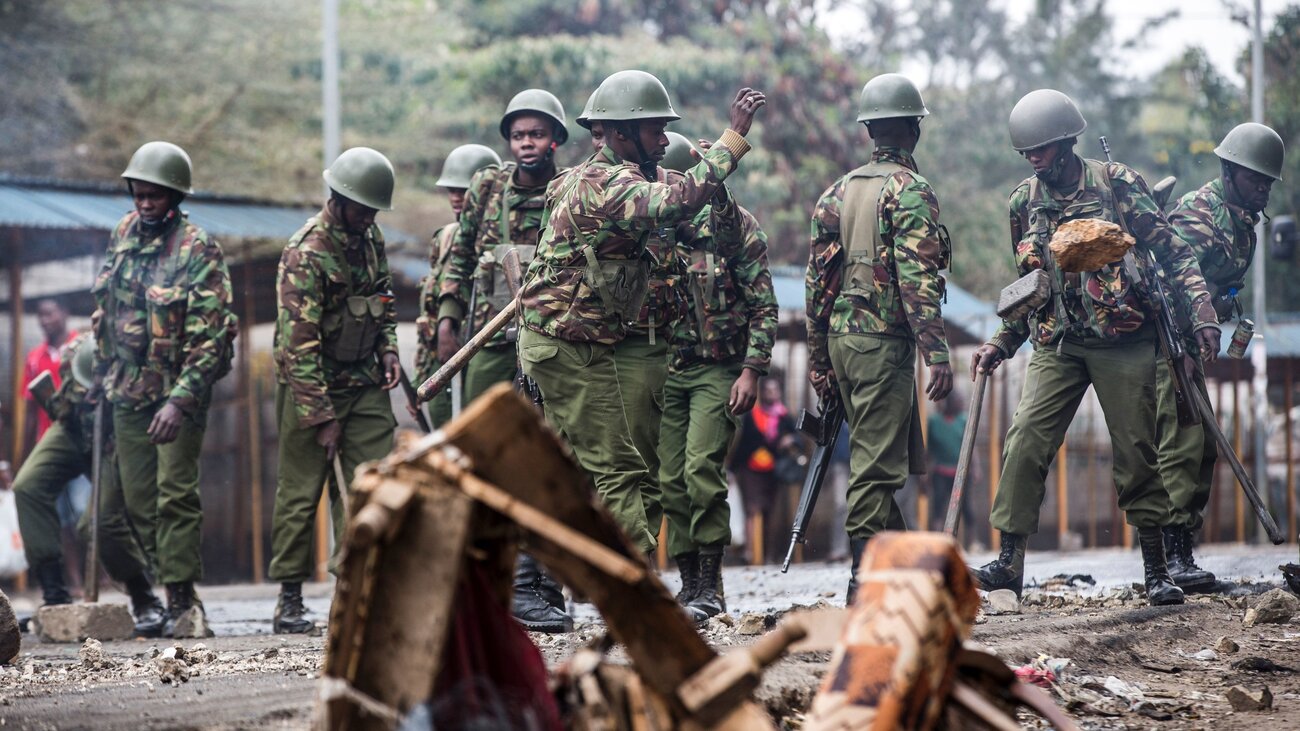 Kenyan police officers clear debris from a barricaded road Friday after an opposition protest roiled a Nairobi neighborhood.
(Luis Tato/AFP/Getty Images)