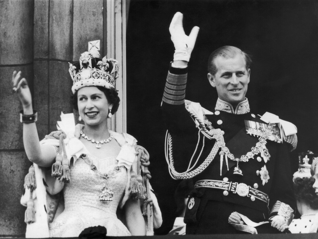 Queen Elizabeth II and the Duke of Edinburgh wave at the crowds from the balcony at Buckingham Palace on June 2, 1953. (Keystone/Getty Images)