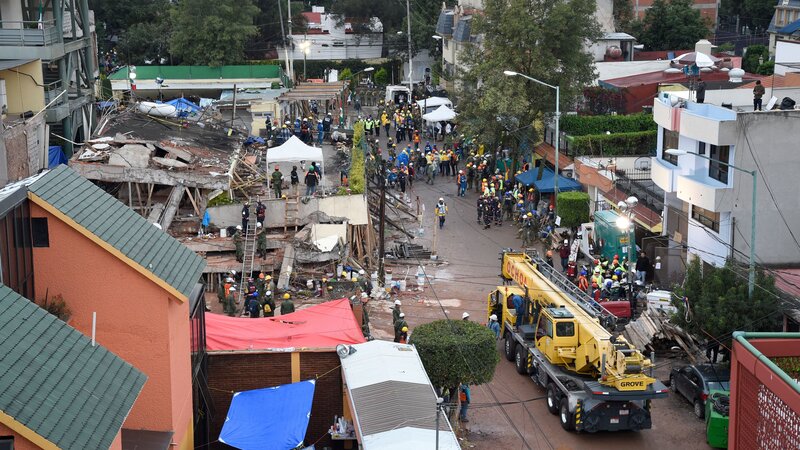 Rescuers, firefighters, policemen, soldiers and volunteers look for survivors in a flattened building in Mexico City on Thursday, as part of a widespread search for people who lived through a strong earthquake. (Alfredo Estrella/AFP/Getty Images)