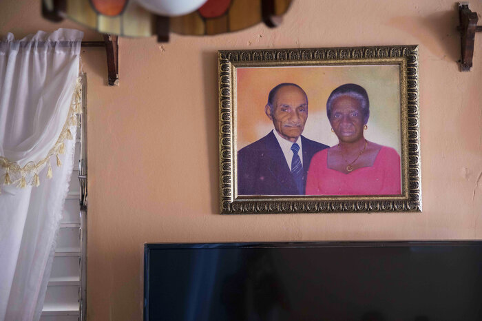 A portrait of Paulina Recio, 84, and her late husband hangs in her home in Restauracion, Dominican Republic.