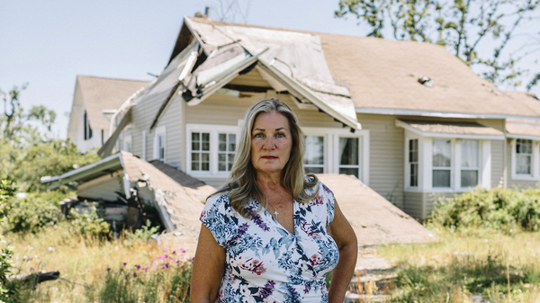 Mayor Margo Anderson stands in front of a storm-damaged home in downtown Lynn Haven, Fla. Much of her town sustained catastrophic damage during Hurricane Michael last year.