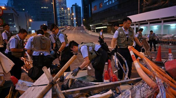 Police officers on Thursday dismantle barricades placed earlier by demonstrators in Hong Kong.