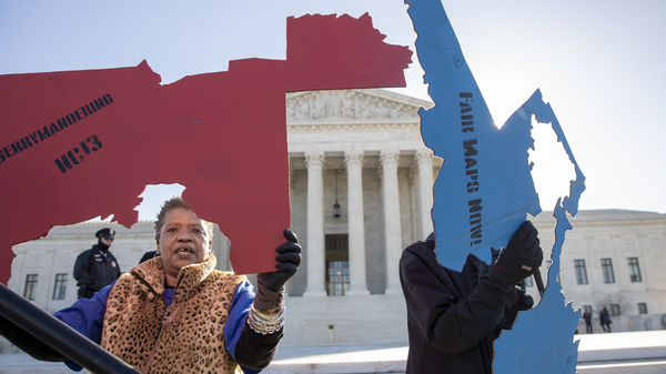 Activists at the Supreme Court opposed to partisan gerrymandering hold up representations of congressional districts from North Carolina (left) and Maryland on March 26. On June 27, justices decided that the practice is beyond the reach of federal courts.