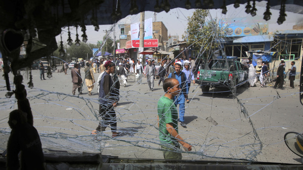 Afghans are seen through a shattered windshield of a bus after an explosion in Kabul, Afghanistan. A suicide car bomber targeted the police headquarters in western Kabul on Wednesday.