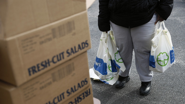 An FDA contract worker collects food and supplies from a food pantry in Baltimore. In the face of a Trump administration proposal that could cause 3 million people to lose federal food assistance, mayors from 70 cities are pushing back.