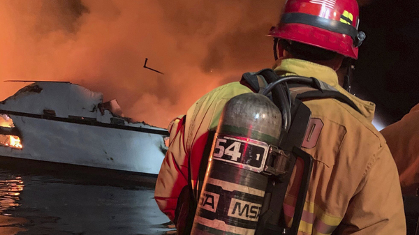 In this photo provided by the Ventura County Fire Department, firefighters respond to a boat fire off the coast of Southern California on Monday. The U.S. Coast Guard said it has launched several boats to help over two dozen people "in distress." off the coast of southern California.
