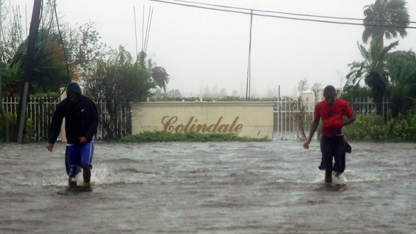Residents wade through a street flooded with water brought on by Hurricane Dorian in Freeport, Bahamas, on Tuesday. The storm spent most of Monday and into the morning Tuesday essentially stalled out over the Bahamas, relentlessly pounding the islands with high winds and catastrophic flooding.