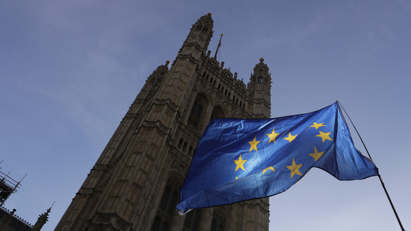 A European Union flag flies Monday outside the Parliament building in London. The multinational bloc has agreed to grant the U.K. another Brexit delay, bumping the deadline to the end of January.