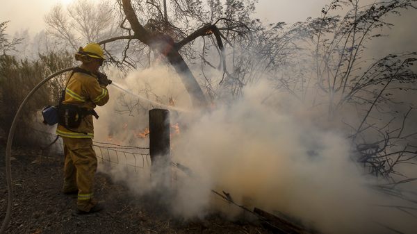 A firefighter battles a wildfire near a ranch in Simi Valley, Calif., on Wednesday. The large new wildfire erupted in wind-whipped Southern California, forcing the evacuation of the Ronald Reagan Presidential Library and nearby homes.