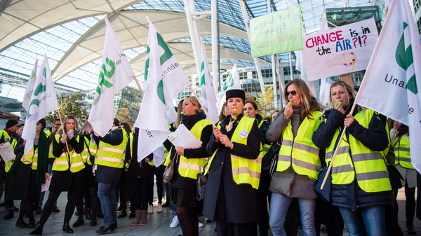 Flight picketing in front of the Munich Airport Thursday, some holding signs with slogans that read "Change is in the air???" Lufthansa has cancelled a total of 1300 flights due to the announced 48-hour strike by flight attendants.