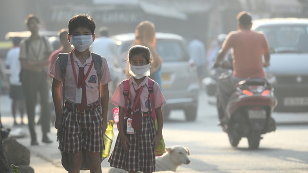 Students cover their faces with masks to protect themselves from air pollution in Delhi.