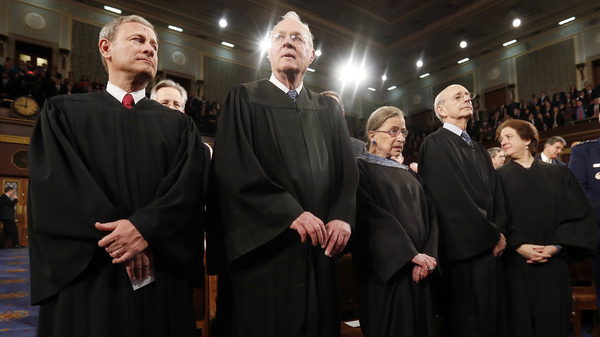Chief Justice John Roberts (left) with his colleagues on the Supreme Court in 2014. He will preside over President Trump