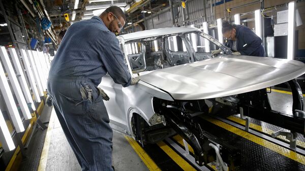 Workers assemble cars at Ford