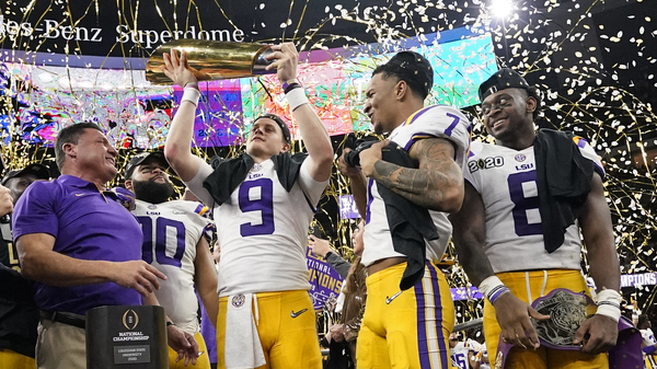 LSU quarterback Joe Burrow holds the trophy after the team