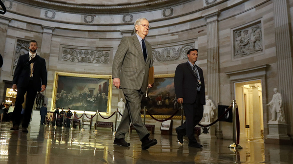Senate Majority Leader Mitch McConnell, R-Ky., (center) walks through the rotunda at the Capitol on Wednesday.
