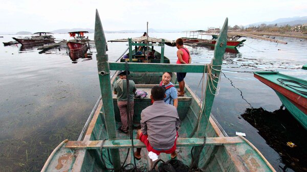 A group of fishermen aboard a boat going to Taal volcano island to rescue their horses and other livestock in Talisay, Batangas, on Sunday.