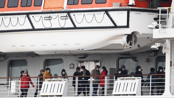 Passengers walk along the deck of the Diamond Princess cruise ship, on which about 3,600 people have been quarantined because of fears of the new COVID-19 coronavirus.