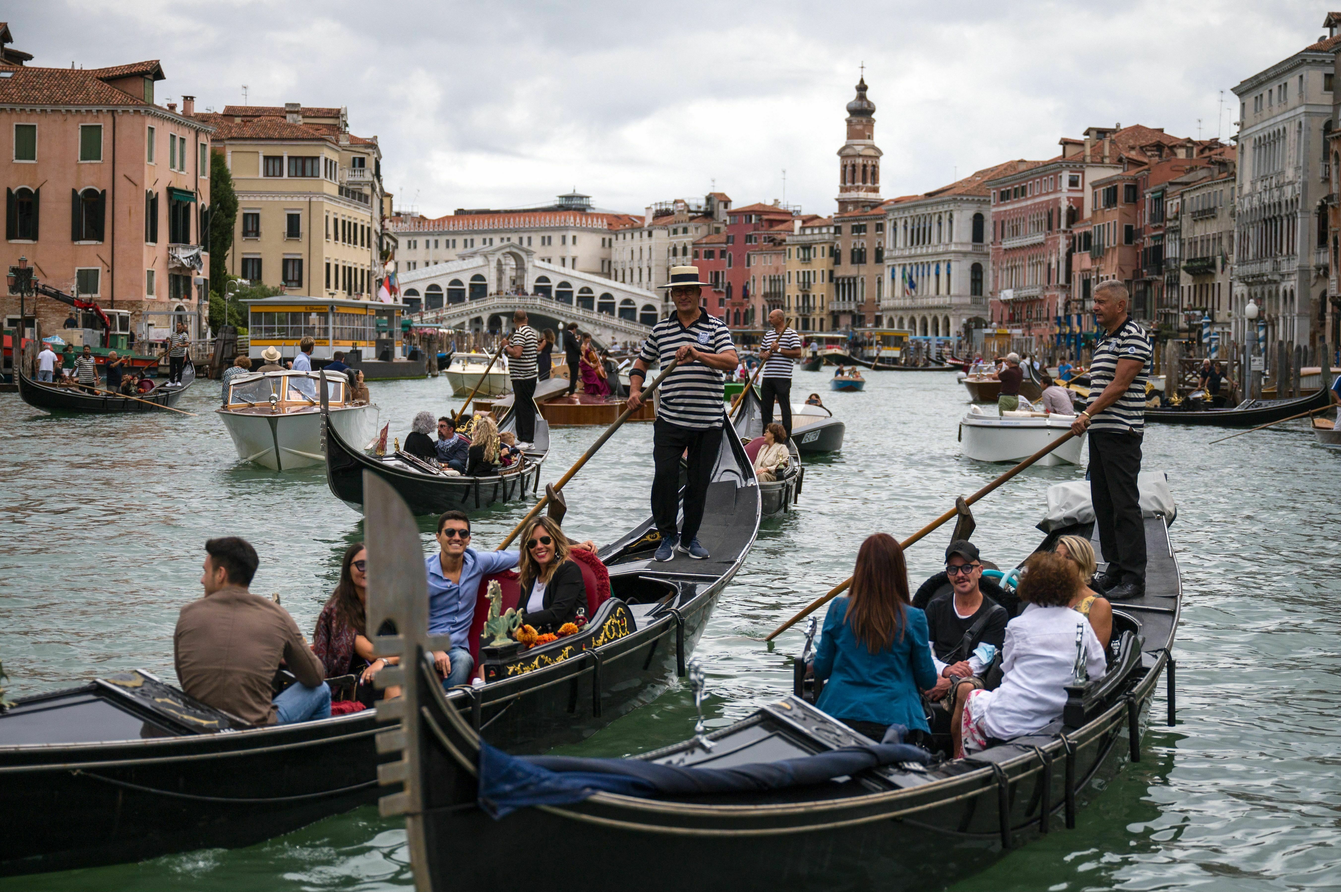 Tourists enjoy a gondola ride on the Grand Canal by the Rialto bridge in Venice in 2021.
